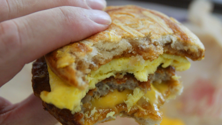 Close up of McGriddle sandwich bit in half showing egg, sausage, and cheese