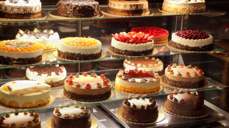 many varieties of cake in a display case at a bakery