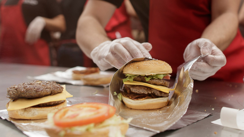 employee preparing five guys burger