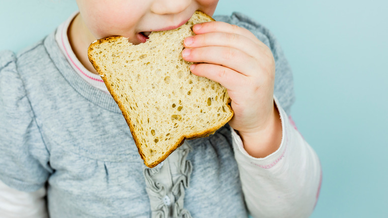 child eating piece of bread