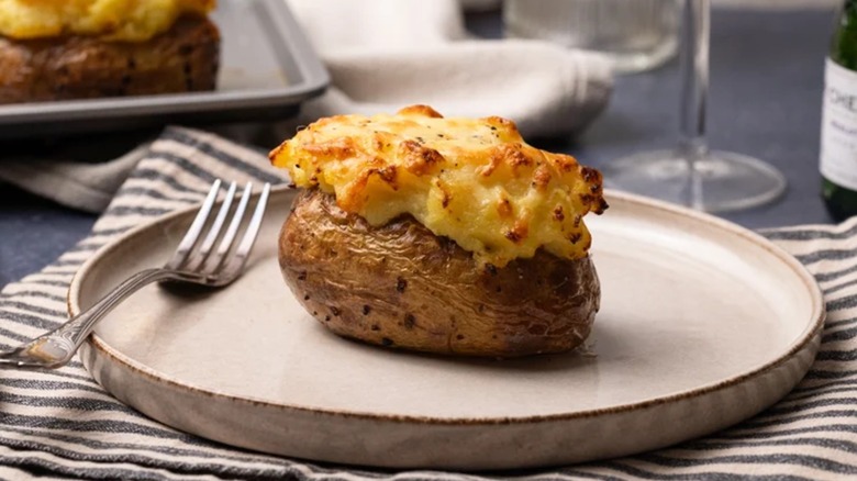 A cottage pie baked potato on a plate with a fork