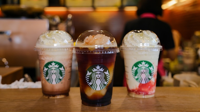 Three colorful Starbucks drinks.