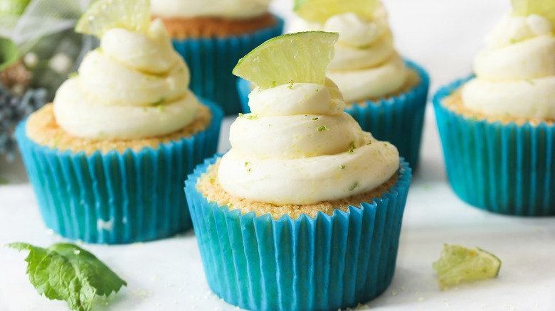 cupcakes in blue liners with lime garnish
