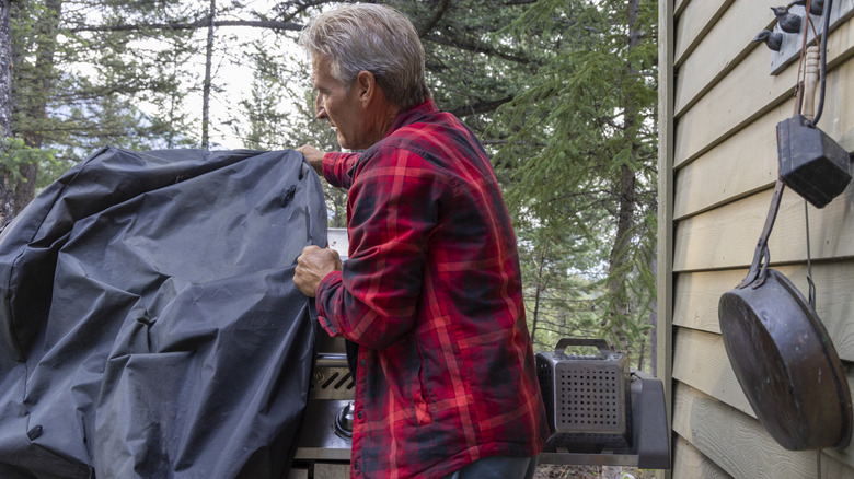 Person covering grill for the season