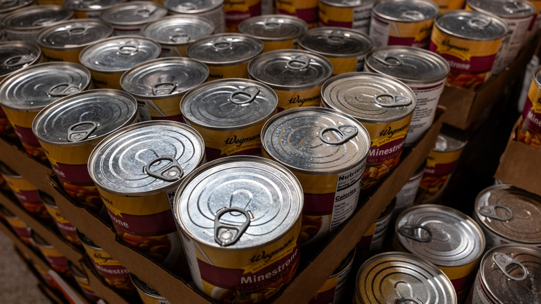 Several stacked cardboard crates of canned soup, with the labels of other of them showing the word "Minestrone"
