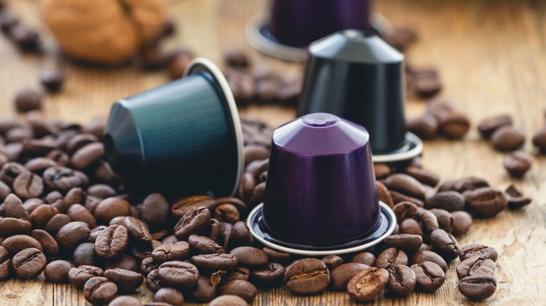 Close-up of three colorful coffee pods on top of coffee beans