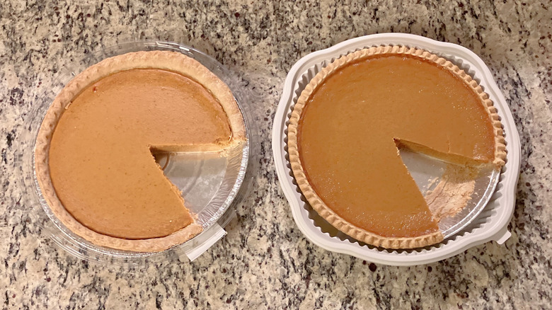 Sam's Club's Members Mark Pumpkin Pie sits next to Costco's Kirkland Signature Pumpkin Pie and both pies have a slice removed