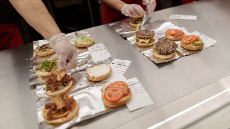 Workers prep multiple Five Guys burger orders
