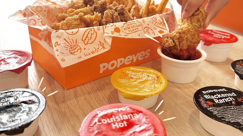 Popeyes sauces spread on table with a box of chicken