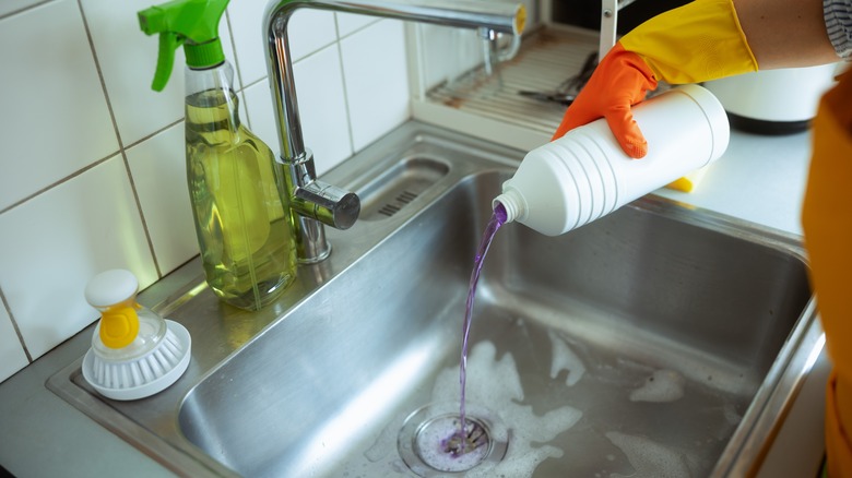 Pouring drain cleaner in sink