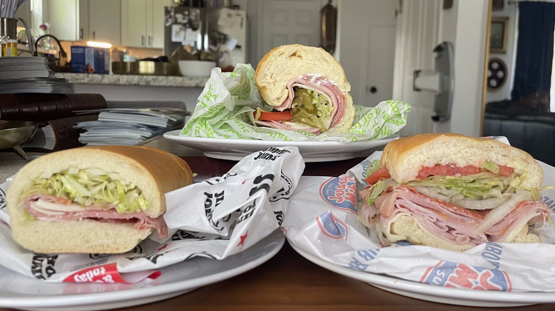 Three Italian sub sandwiches in profile on plates