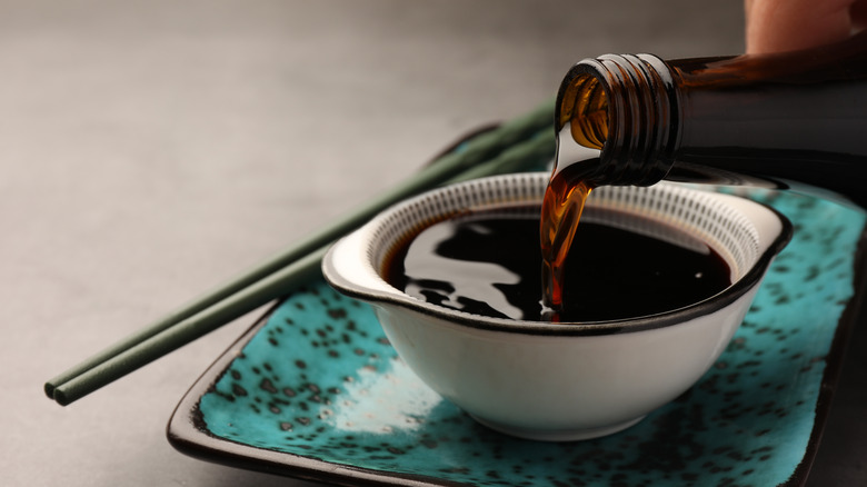 Soy sauce being poured into a dipping bowl