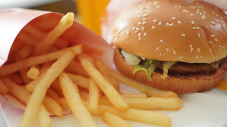 a fast food burger on a sesame seed bun with fries