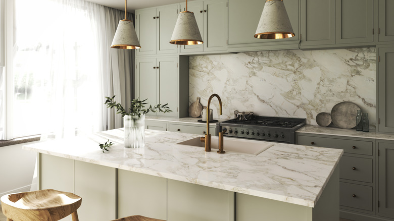 Greige-colored kitchen with a marble island and countertops