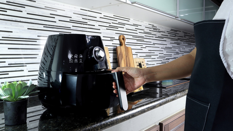 person using an air fryer