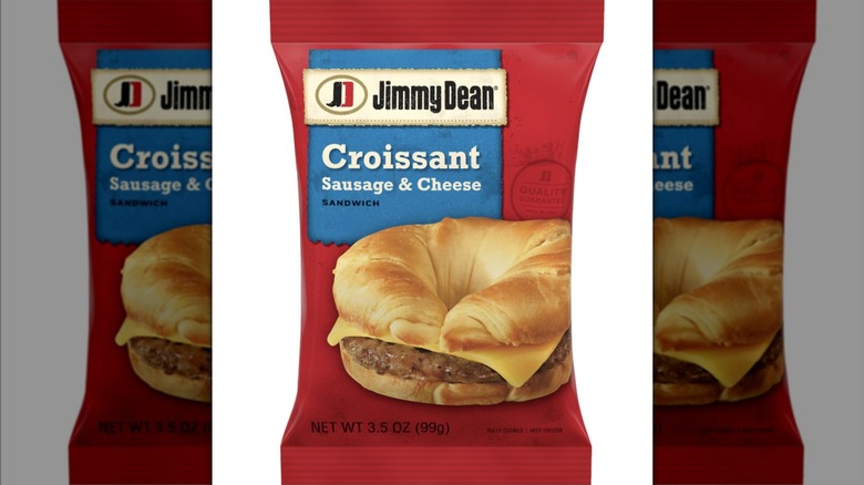 Red package displaying a croissant sandwich with sausage patty and cheese.