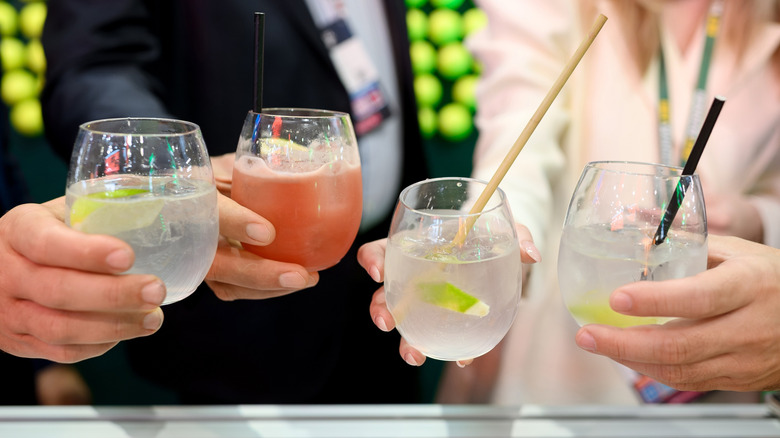 group of people holding clear stemless wine glasses