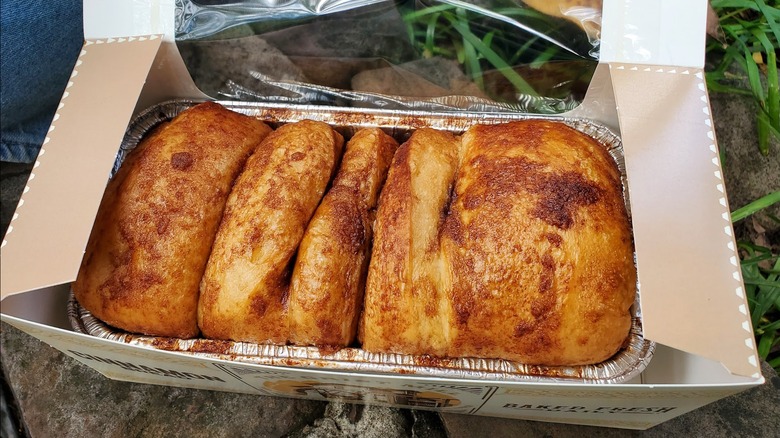 An aluminum tin full of golden brown discs of cinnamon-sprinkled bread.