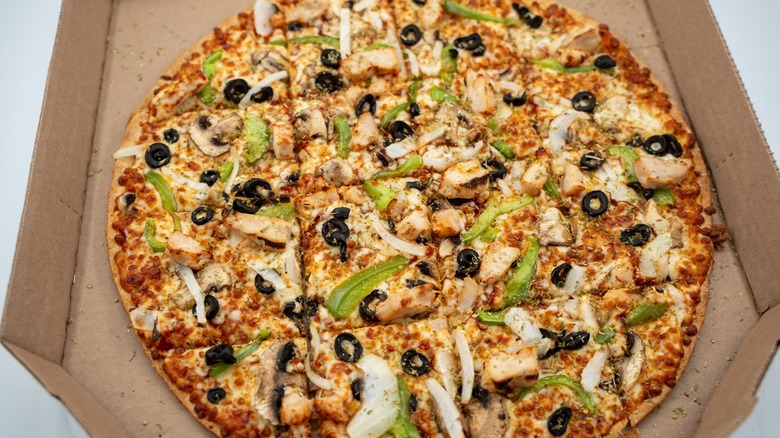 Pizza in a box covered in toppings