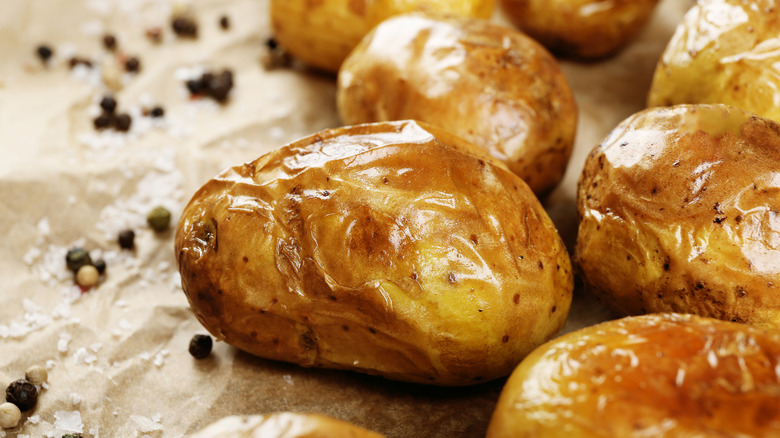 whole baked potatoes on parchment paper
