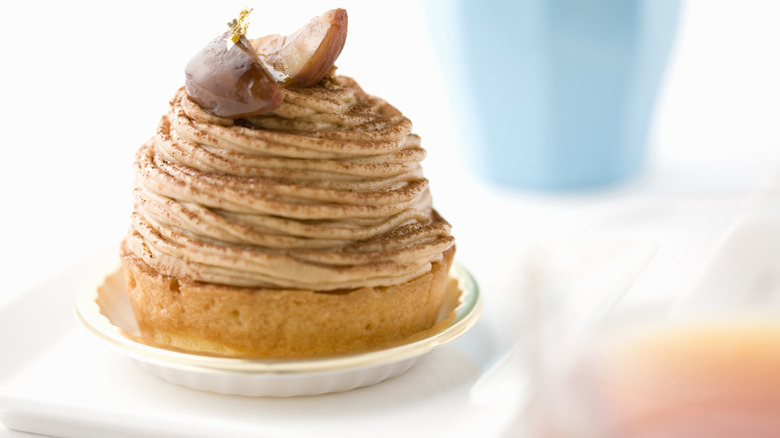 Mont Blanc dessert garnished with candy chestnuts and a flake of edible gold