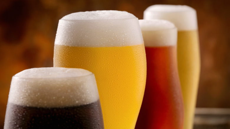 Close-up of four different colored beers lined up 