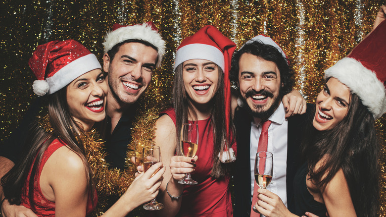 Young people celebrating Christmas with santa hats and champagne