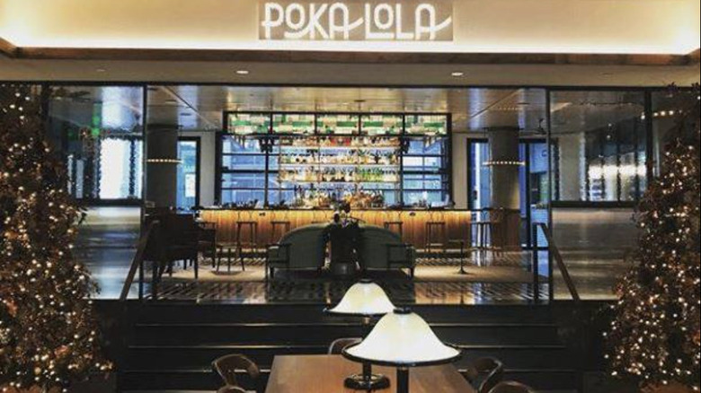 Interior of Poka Lola Social Club decorated for Christmas with trees and lights.