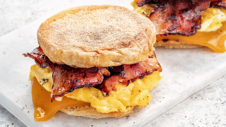 breakfast sandwich with eggs, cheese and bacon on a tray