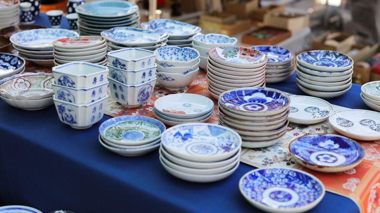 Stacks of assorted vintage plates on table