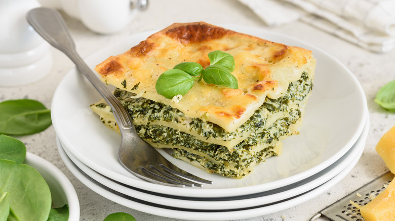 slice of spinach lasagna on a plate with fork