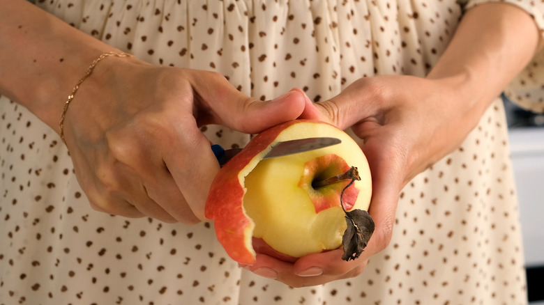 Person peeling an apple with a paring knife