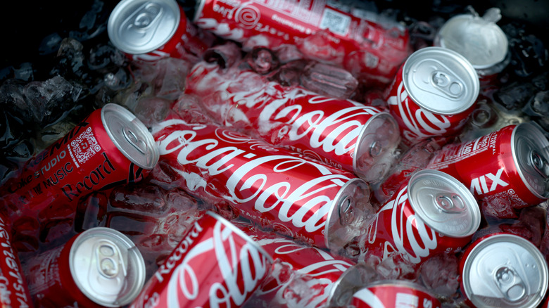 Red Coke cans submerged in ice cubes