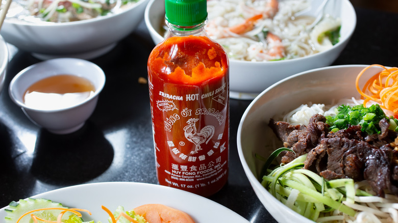 sriracha bottle with assortment of meals