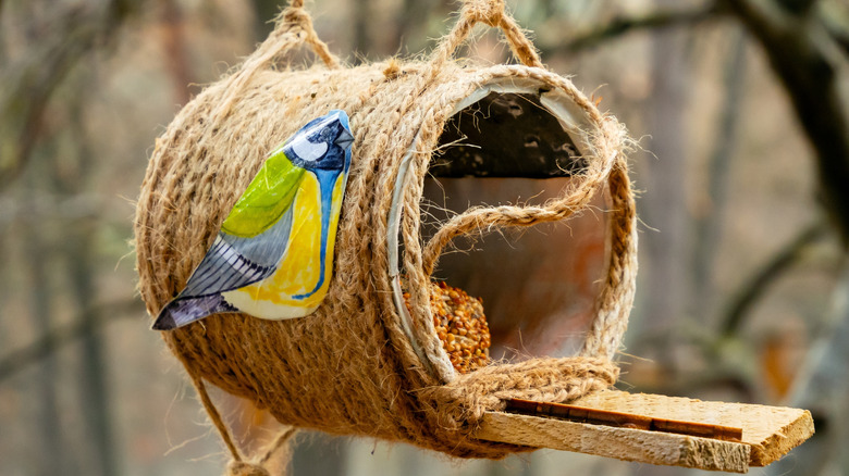 DIY can bird feeder wrapped in twine and hanging in a yard