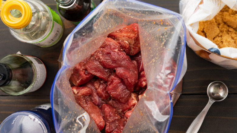 Marinade ingredients with meat in a plastic zip top bag