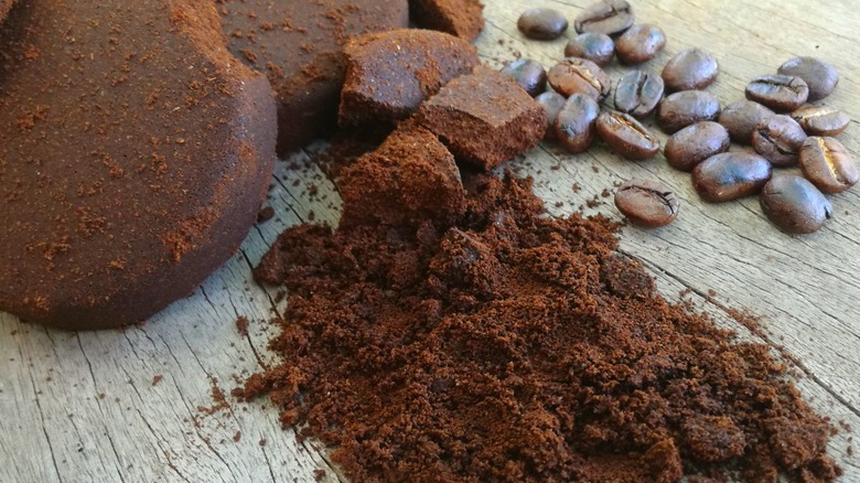 Used coffee grounds and coffee beans on a wood background