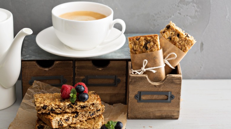 homemade granola bars plus a cup of coffee and other granola bars wrapped in wax paper