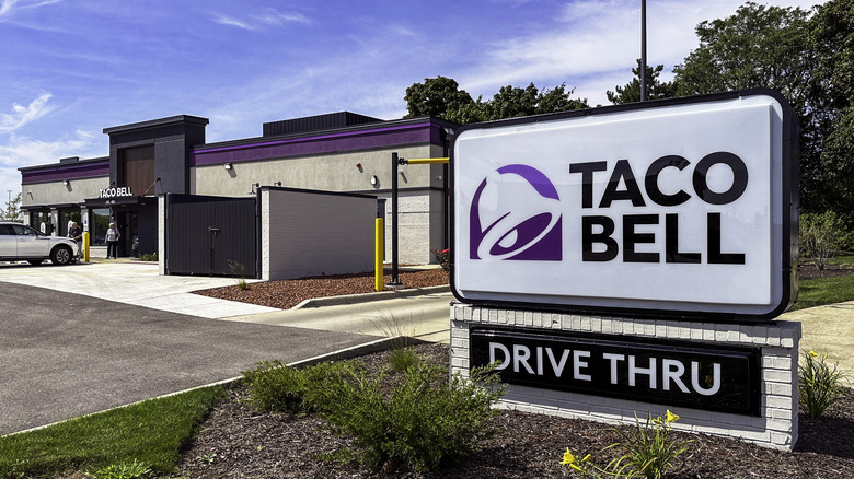Taco Bell Drive Thru sign in front of restaurant and blue sky