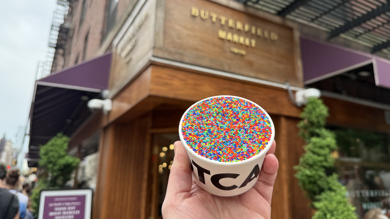 A Dotcake held up high in front of New York's Butterfield Market