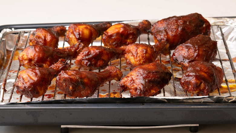 baked Dr Pepper barbecue chicken on wire rack on top of lined baking sheet