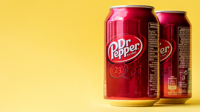 Dr. Pepper cans on yellow background