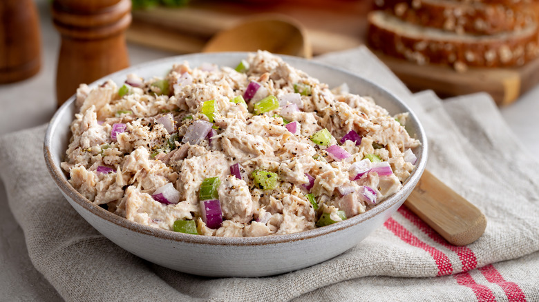 A bowl of tuna salad with red onion and celery chunks