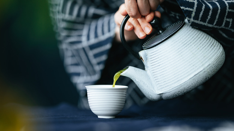 Woman pouring kombu-cha from kettle