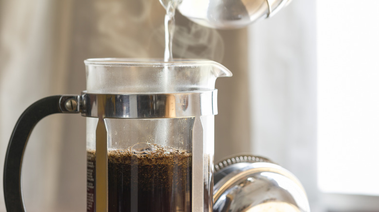 Close-up of a person brewing French press coffee