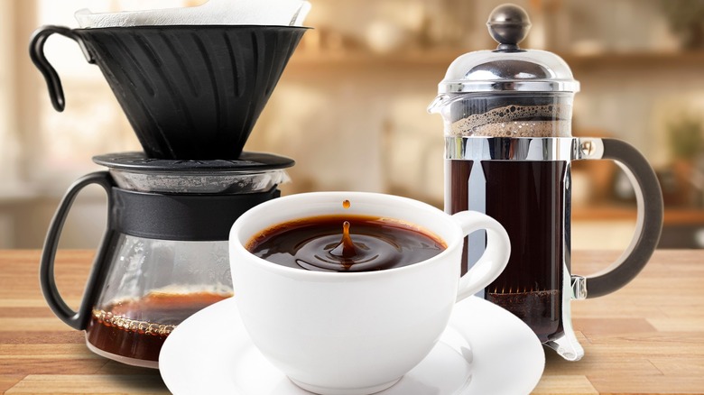 Drip coffee maker and french press behind cup of coffee