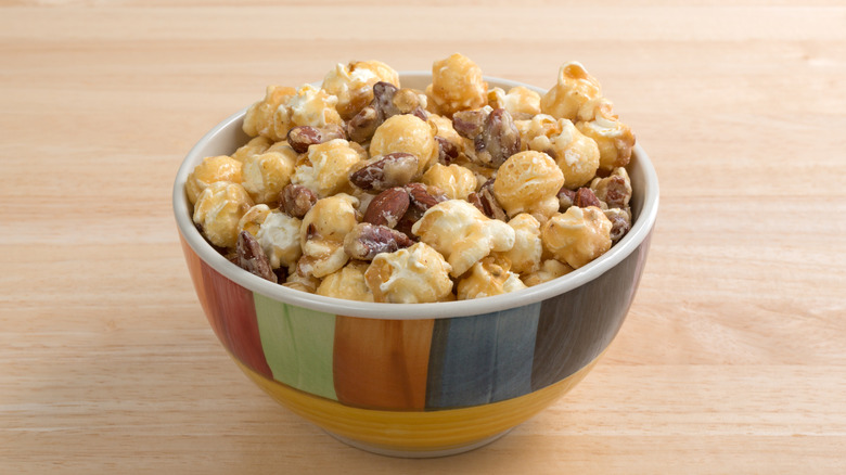 Mixed glazed nuts in a bowl with popcorn
