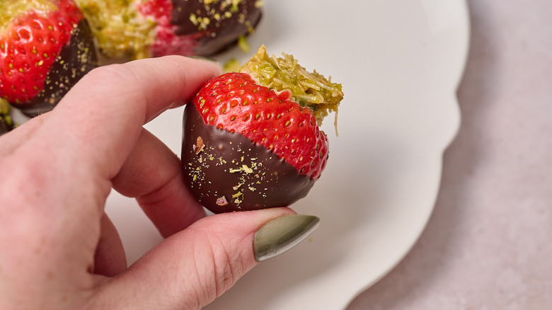 hand holding chocolate covered strawberry