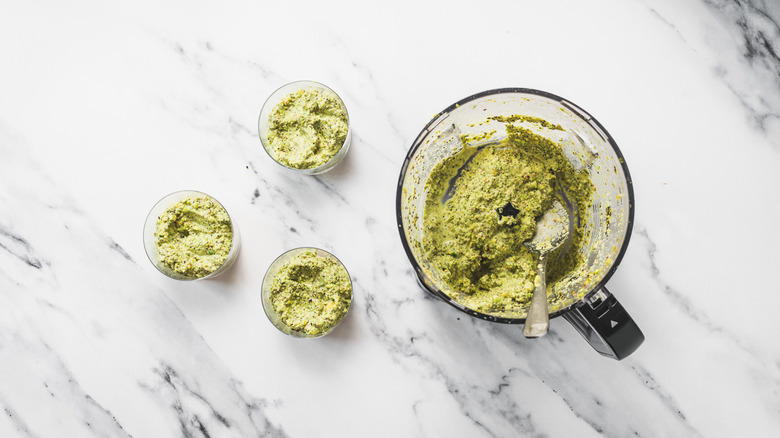 Glasses beside food processor with Dubai pistachio chia pudding.