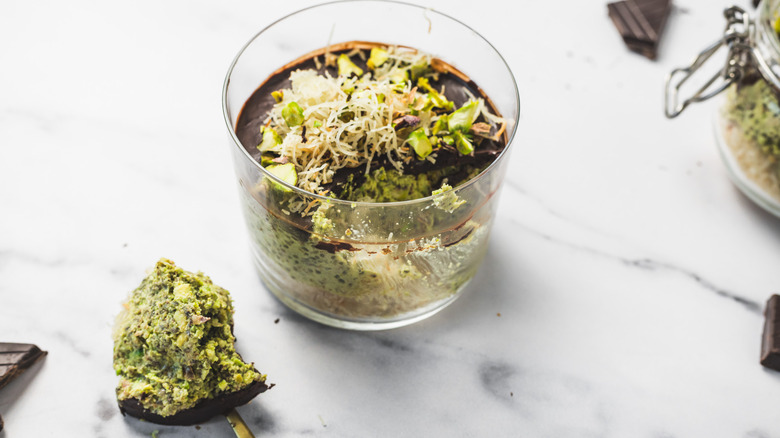 Close up on a cup of Dubai style pistachio chia pudding with spoonful taken out.